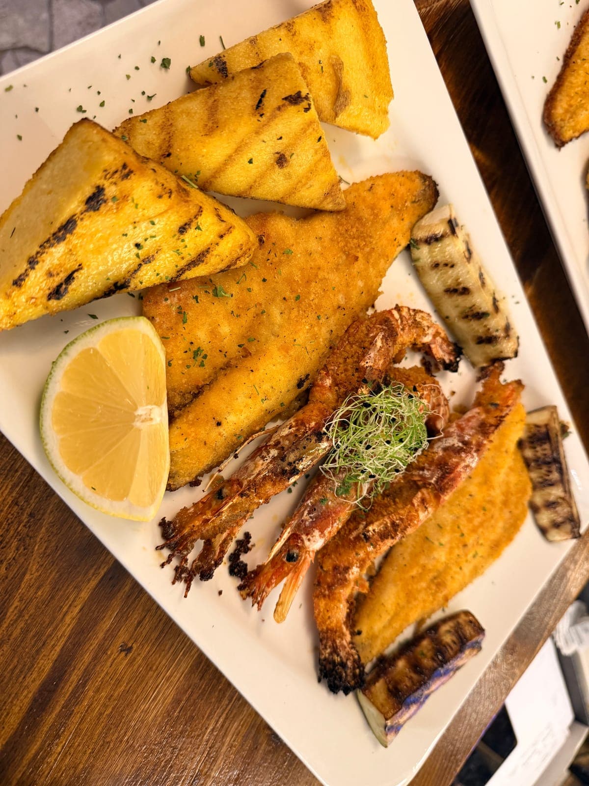 Pesce impanato, gamberi e verdure grigliate