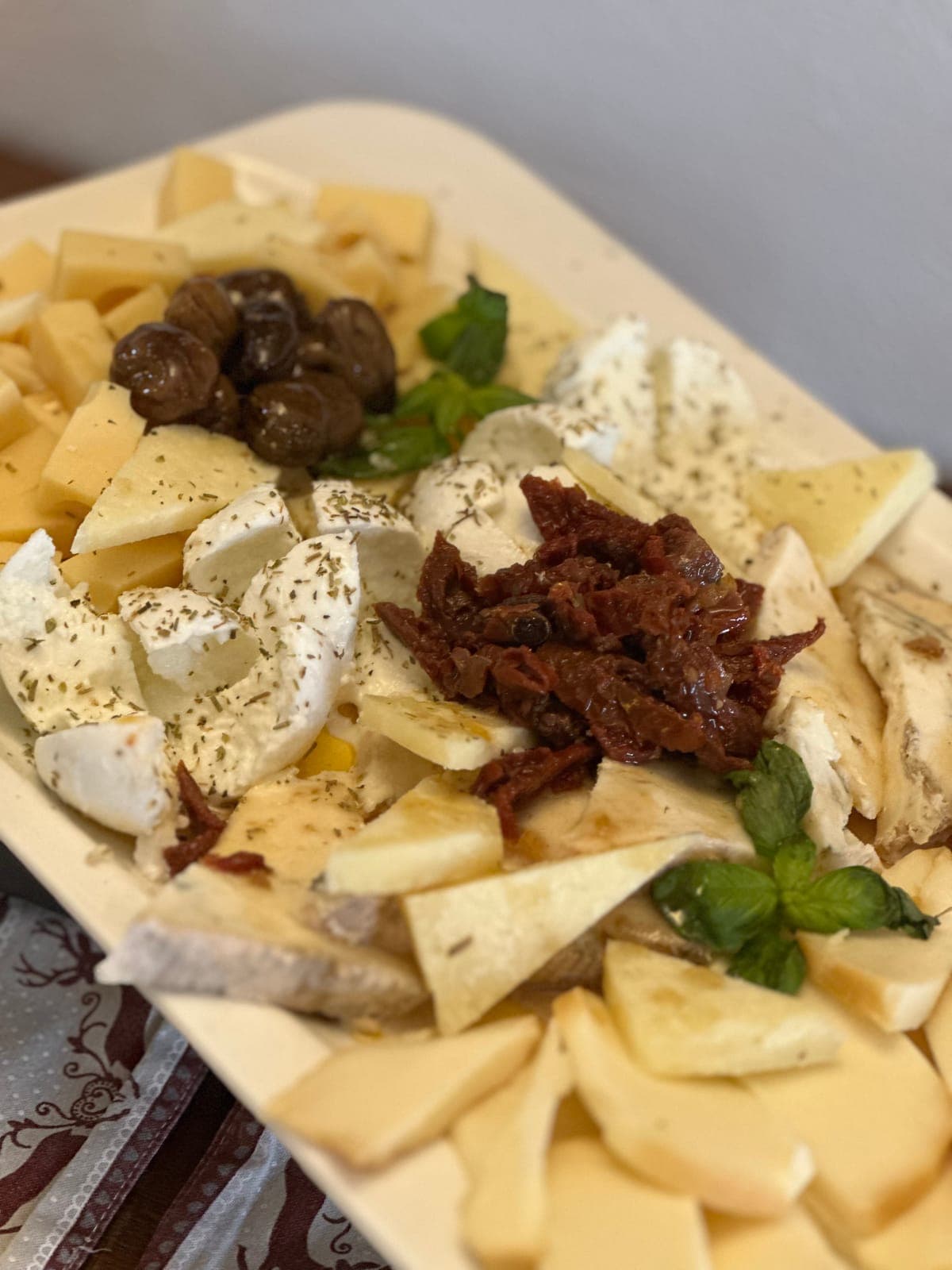 Tagliere di formaggi con olive e pomodori secchi